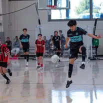 IDLeague07 Boys playing indoor soccer game in gym.