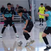 IDLeague09 Indoor soccer match with focused players.