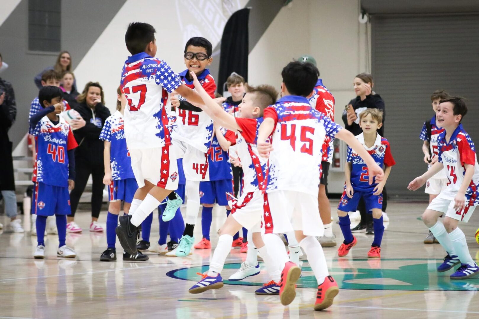 2J2A5497_Original Children playing indoor soccer, celebrating together.